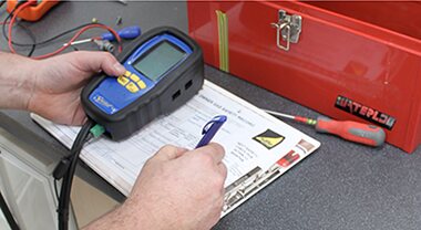 Engineer recording readings with a flue gas analyser