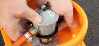 Engineer fitting a regulator to an LPG gas bottle